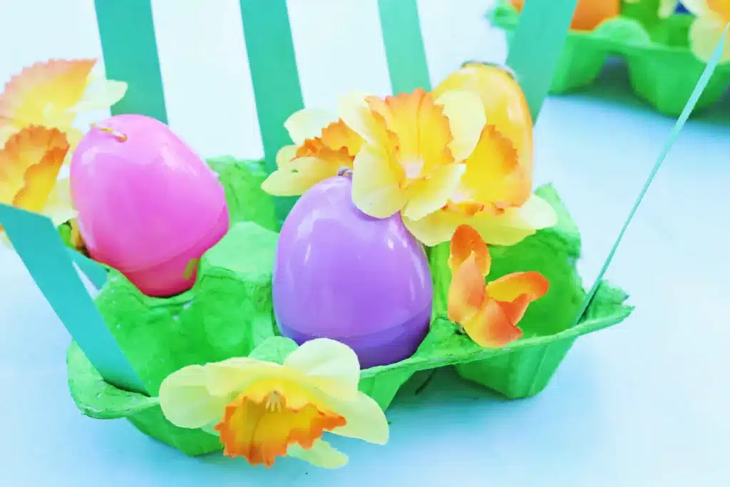 Easter Egg Garden Craft - Cultivating Brilliant Minds an easter egg garden craft that has an egg carton painted green with plastic easter eggs, flowers, and strips of green paper for grass