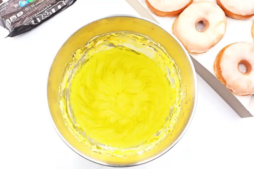 Dr. Seuss Put Me in the Zoo Donuts - Cultivating Brilliant Minds icing dyed yellow in a mixing bowl