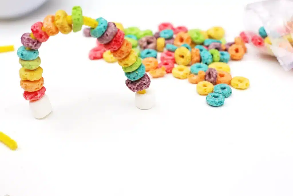 Froot Loops Rainbow Snack - Cultivating Brilliant Minds a rainbow made out of froot loops and marshmallows on pipe cleaners