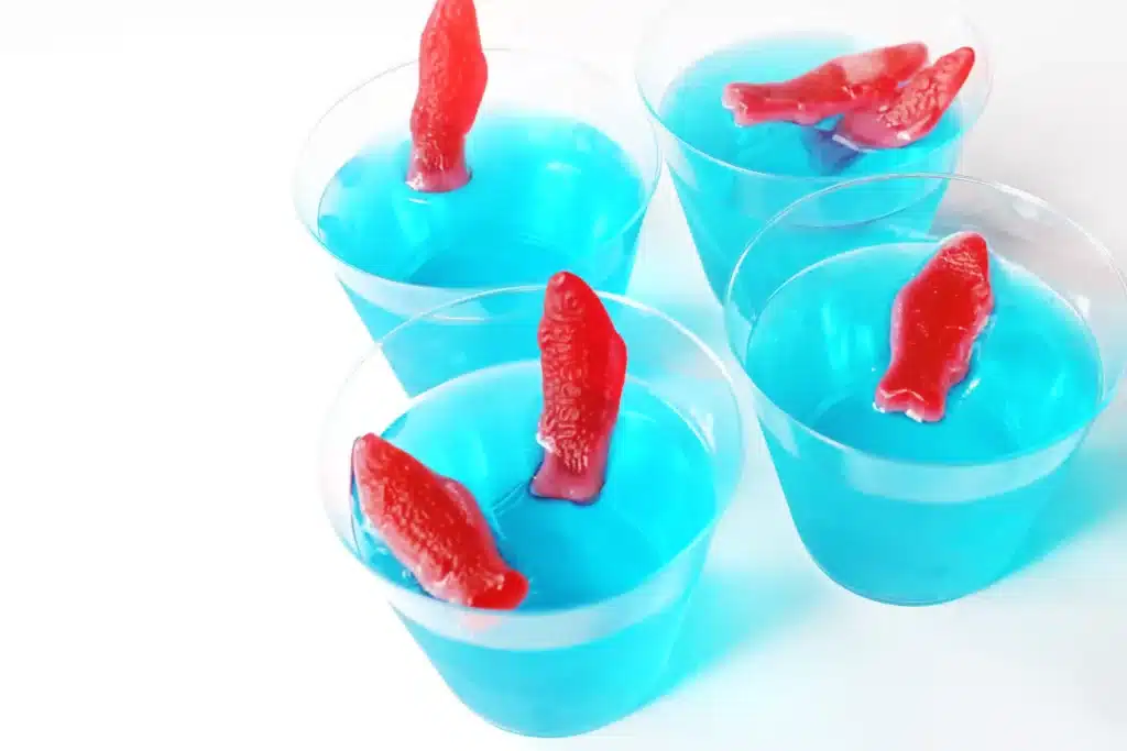Dr. Seuss One Fish Two Fish Jello Cups - Cultivating Brilliant Minds blue jello cups with red swedish fish on top
