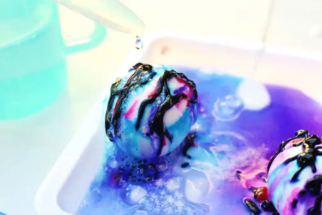 Galaxy Easter Eggs - Cultivating Brilliant Minds a pipette dropping vinegar on an egg covered in baking soda paste and food coloring
