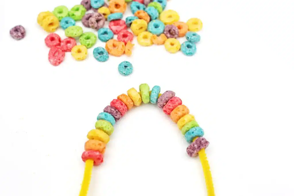 Froot Loops Rainbow Snack - Cultivating Brilliant Minds a pipe cleaner with froot loops threaded on in rainbow order