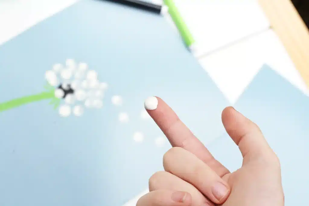 Fingerprint Dandelions - Cultivating Brilliant Minds white paint on a child's finger