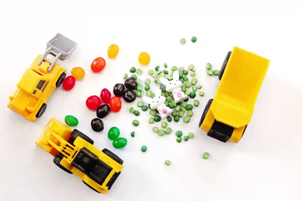 Easter Construction Sensory Bin - Cultivating Brilliant Minds split peas, jelly beans, toy bunnies, and construction vehicles