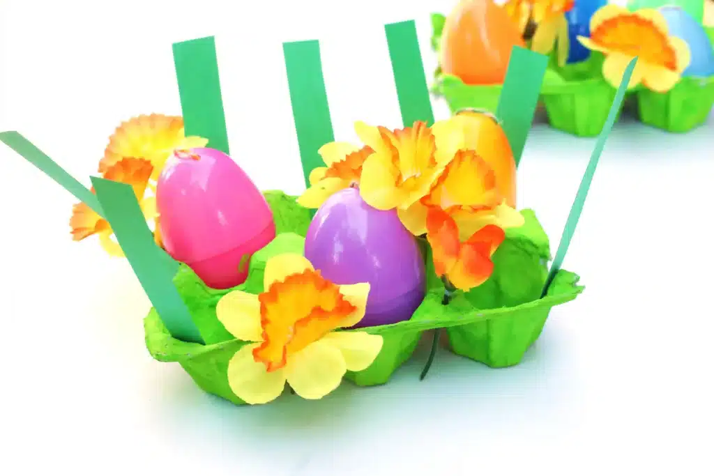 Easter Egg Garden Craft - Cultivating Brilliant Minds an easter egg garden craft that has an egg carton painted green with plastic easter eggs, flowers, and strips of green paper for grass