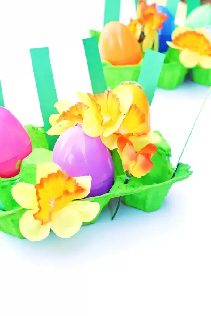 Easter Egg Garden Craft - Cultivating Brilliant Minds an easter egg garden craft that has an egg carton painted green with plastic easter eggs, flowers, and strips of green paper for grass