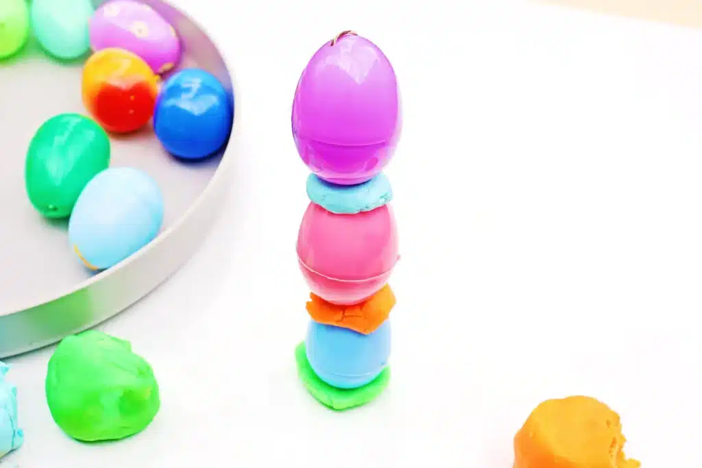 Easter Egg Tower STEM Project - Cultivating Brilliant Minds easter eggs stacked on top of each other with playdough in the middle to hold them up