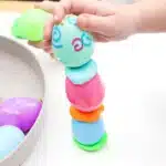 Easter Egg Tower STEM Project - Cultivating Brilliant Minds a kid stacking an easter egg tower with playdough in between each egg