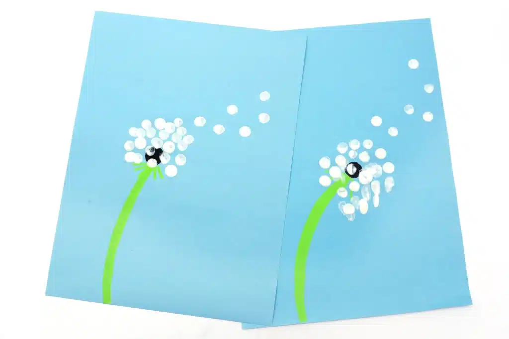 Fingerprint Dandelions - Cultivating Brilliant Minds a dandelion painted on a blue piece of paper with fingerprints for the flower