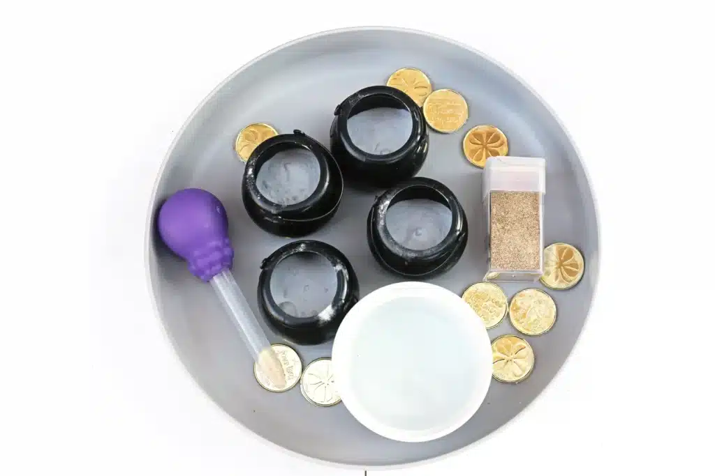 Fizzy Pot of Gold Experiment - Cultivating Brilliant Minds black cauldron pots, gold glitter, baking soda, vinegar, and a pipette