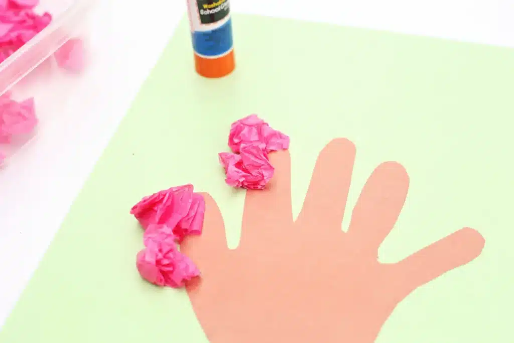 Handprint Cherry Blossom Tree - Cultivating Brilliant Minds crumbled pink tissue paper glued to a handprint trunk