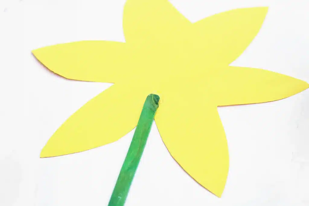 Cupcake Liner Daffodil - Cultivating Brilliant Minds a green popsicle stick glued to a flower cut out of yellow construction paper