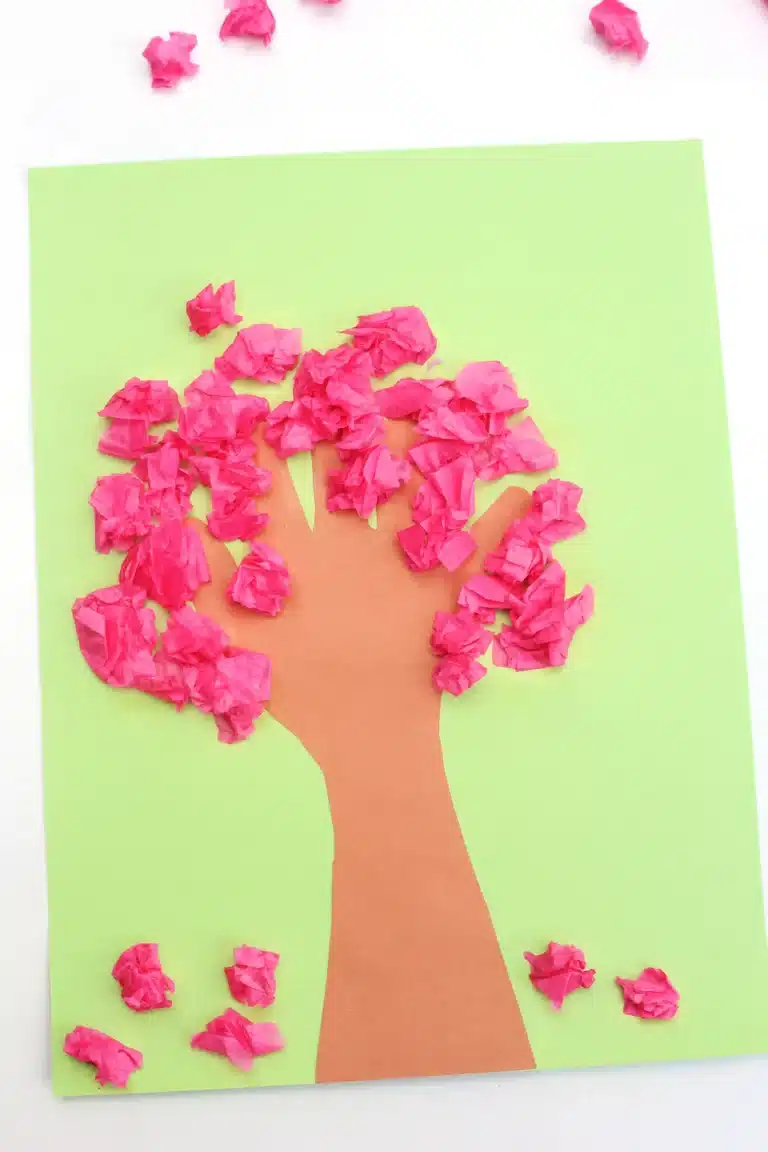 a handprint cherry blossom tree that uses a handprint as the trunk and crumbled pink tissue paper as the cherry blossoms