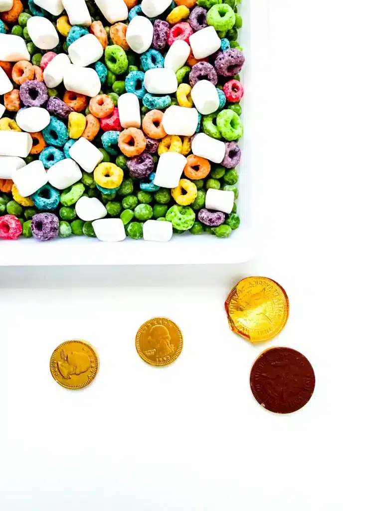 Edible St. Patrick's Day Sensory Bin - Cultivating Brilliant Minds an unwrapped chocolate coin next to the sensory bin