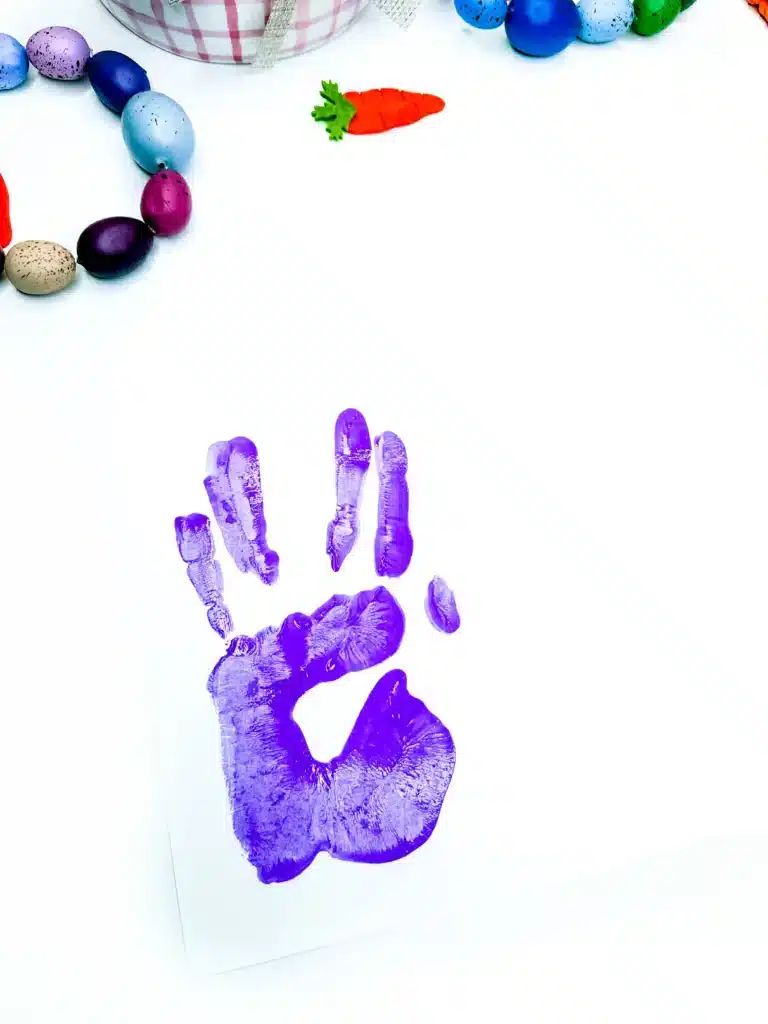 Bunny Handprint Craft For Easter - Cultivating Brilliant Minds a purple handprint stamped on paper