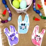 Bunny Handprint Craft For Easter - Cultivating Brilliant Minds a handprint stamped on paper with a bunny face drawn on it