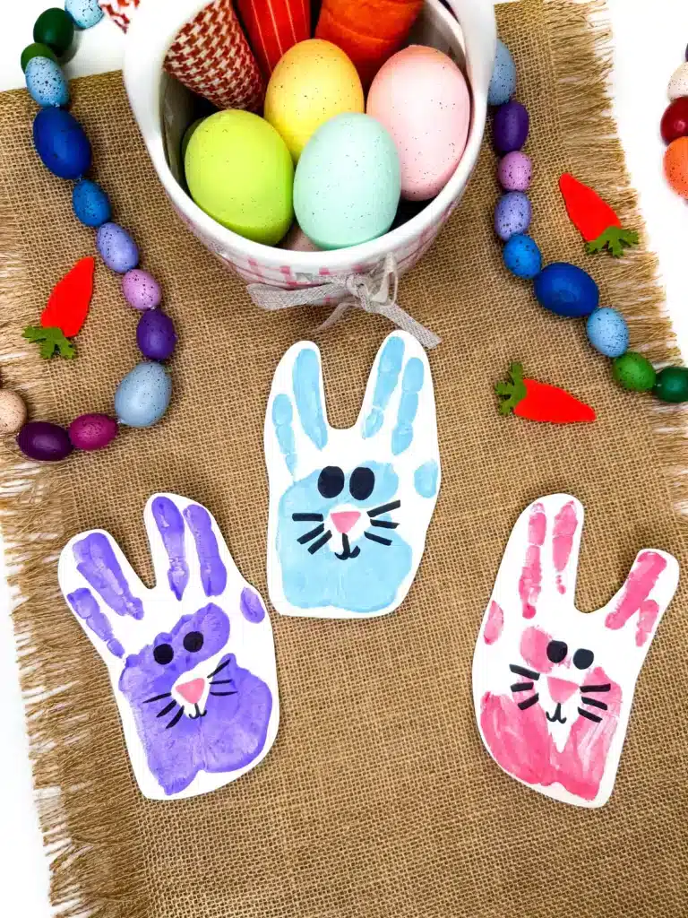 Bunny Handprint Craft For Easter - Cultivating Brilliant Minds a handprint stamped on paper with a bunny face drawn on it