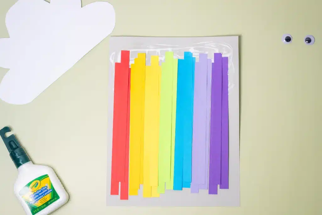 Rainbow Cloud Craft - Cultivating Brilliant Minds colored strips of paper in rainbow order glued on a piece of paper