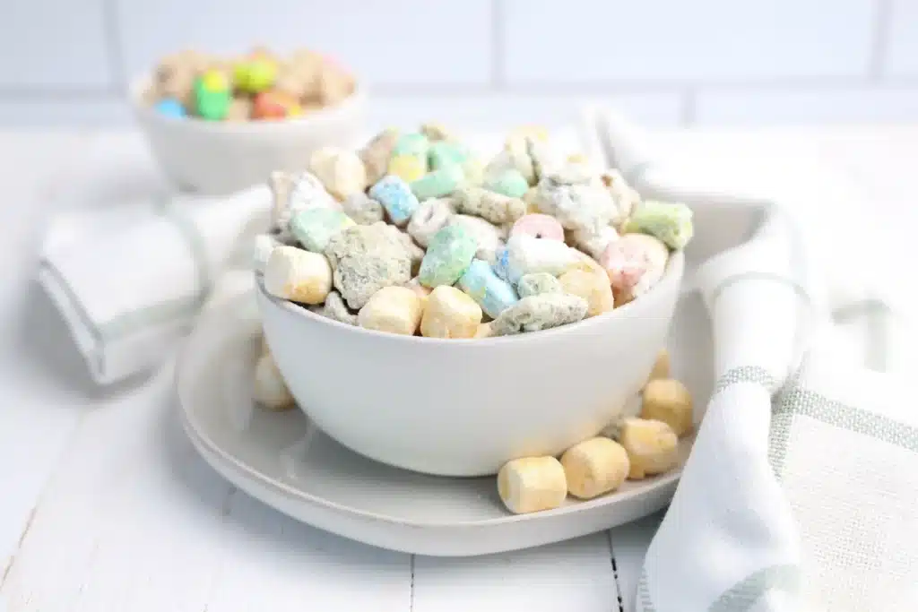 Lucky Charms Puppy Chow for St. Patrick's Day - Cultivating Brilliant Minds st. patrick's day muddy buddies in a white bowl