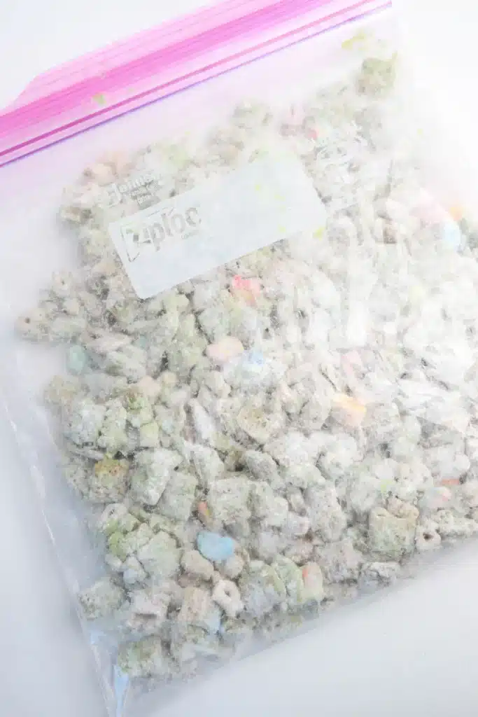 Lucky Charms Puppy Chow for St. Patrick's Day - Cultivating Brilliant Minds chex mix and lucky charms coated with green melted candy melts in a plastic bag