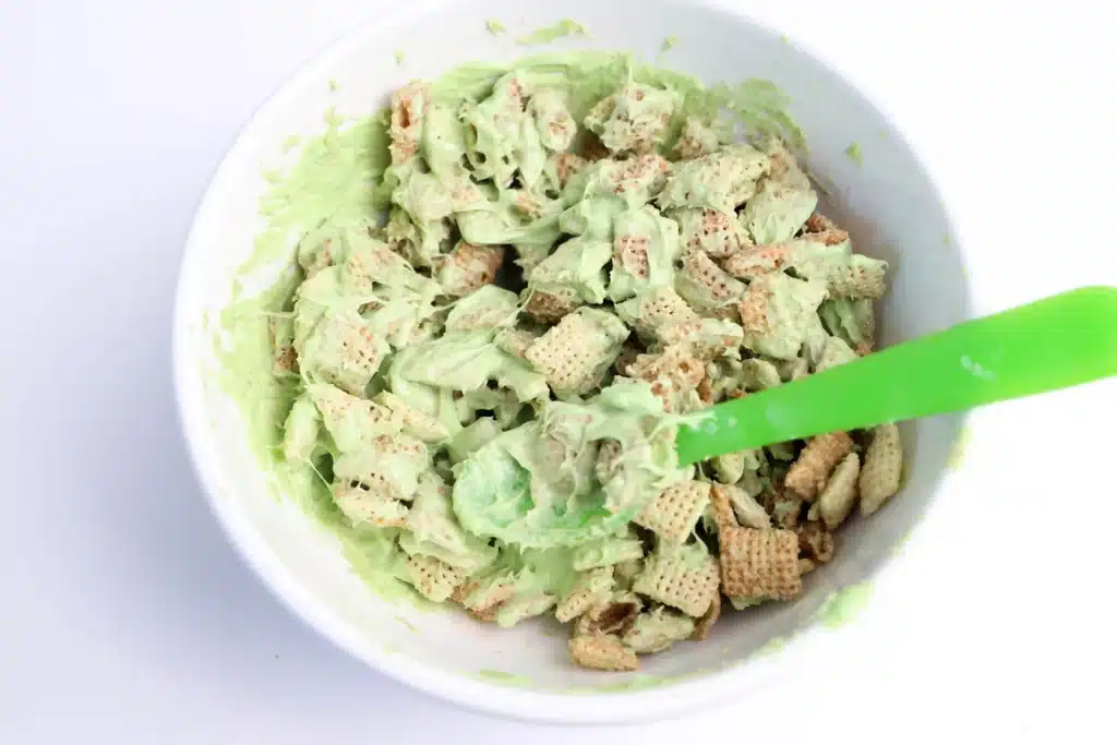 Lucky Charms Puppy Chow for St. Patrick's Day - Cultivating Brilliant Minds chex mix coated with melted green candy melts