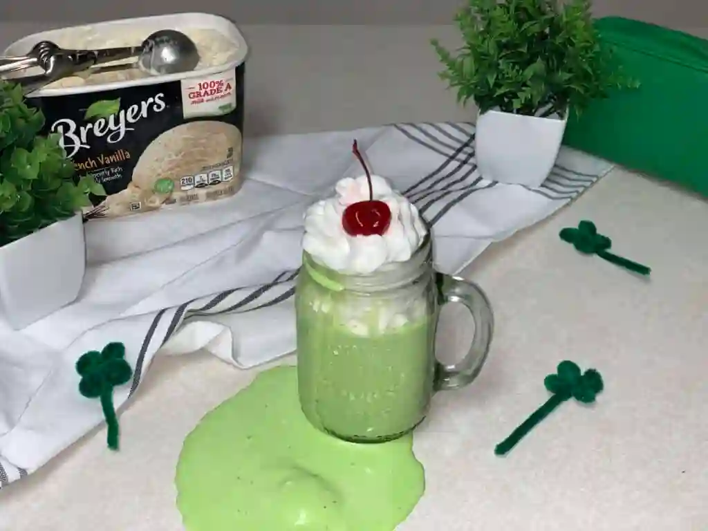 St. Patrick's Day Treats for Kids - Cultivating Brilliant Minds a green shamrock shake with whipped cream and a cherry
