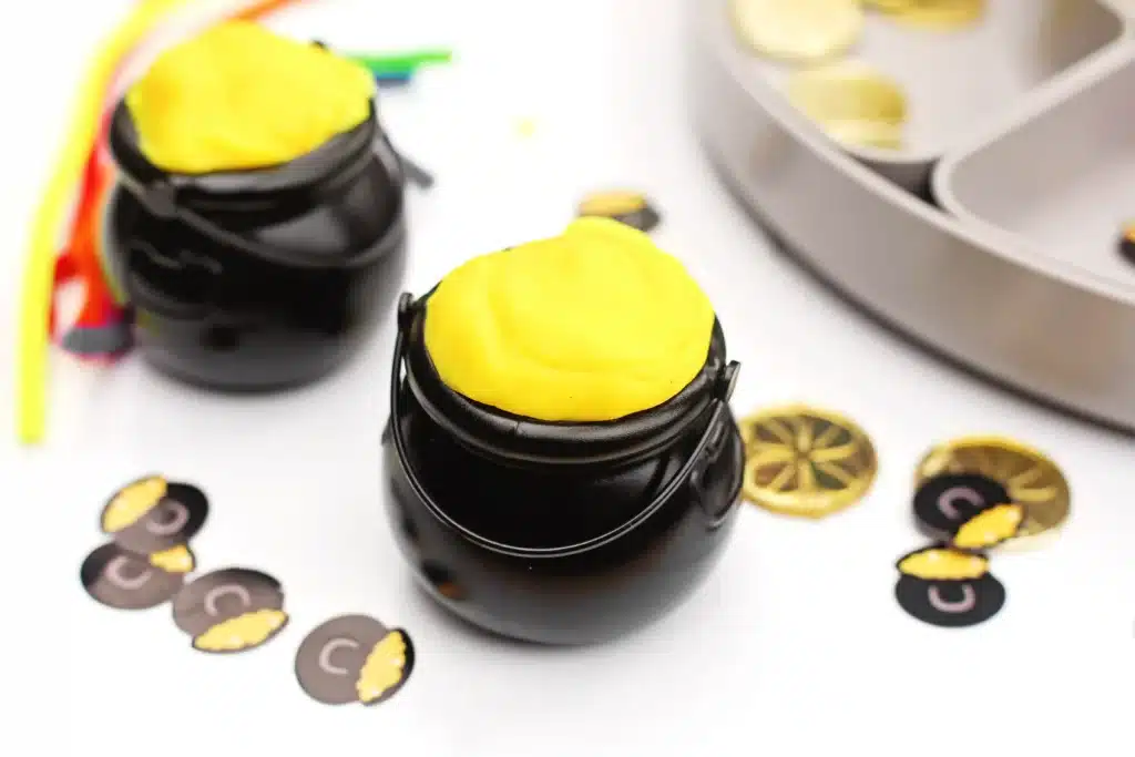 Pot of Gold Playdough Tray - Cultivating Brilliant Minds cauldrons with yellow playdough inside