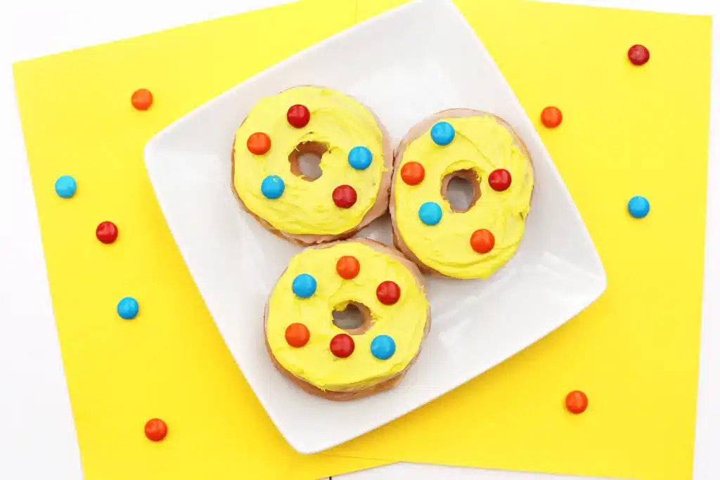 Dr. Seuss Put Me in the Zoo Donuts - Cultivating Brilliant Minds glazed donuts with yellow icing and red and blue m&ms on top