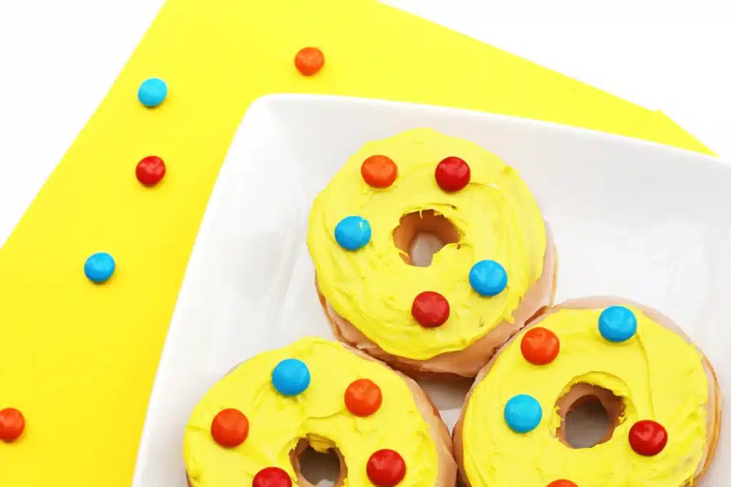 Dr. Seuss Put Me in the Zoo Donuts - Cultivating Brilliant Minds glazed donuts with yellow icing and red and blue m&ms on top