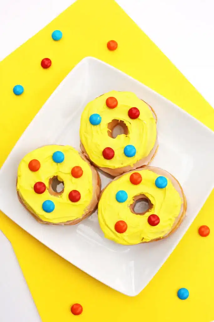 Dr. Seuss Put Me in the Zoo Donuts - Cultivating Brilliant Minds glazed donuts with yellow icing and red and blue m&ms on top