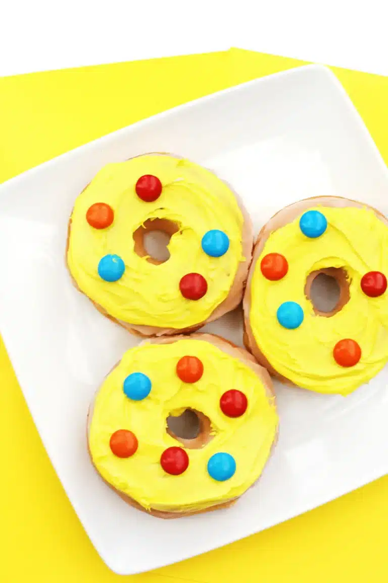 glazed donuts with yellow icing and red and blue m&ms on top