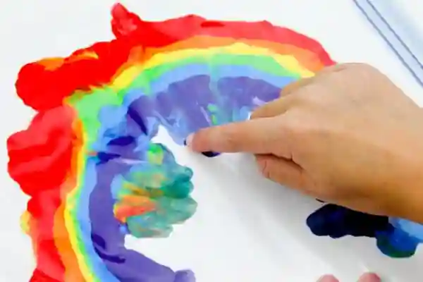 Easy Rainbow Art Projects for St. Patrick's Day - Cultivating Brilliant Minds paint in the shape of a rainbow inside a plastic bag