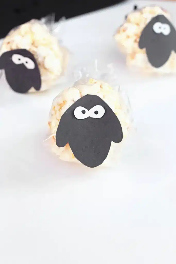 Sheep Popcorn Balls - Cultivating Brilliant Minds a popcorn ball with a construction paper sheep face on it to make a sheep popcorn ball