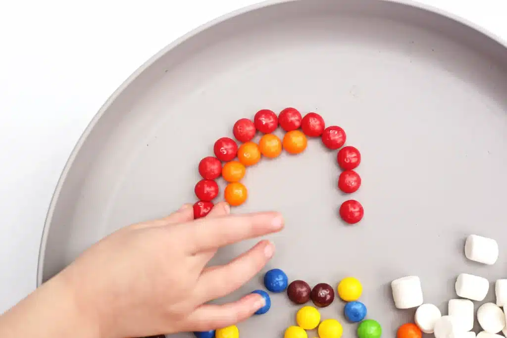 Skittles Rainbow Fine Motor Activity - Cultivating Brilliant Minds skittles arranged into a rainbow
