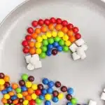 Skittles Rainbow Fine Motor Activity - Cultivating Brilliant Minds skittles and marshmallows organized into a rainbow on a plate