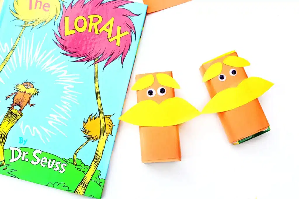 Dr. Seuss The Lorax Juice Boxes - Cultivating Brilliant Minds juice boxes wrapped in orange paper and decorated to look like The Lorax next to Dr. Seuss's book "The Lorax"