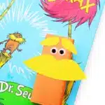 juice boxes wrapped in orange paper and decorated to look like The Lorax next to Dr. Seuss's book "The Lorax"