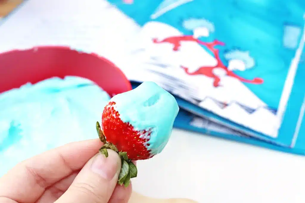 Thing 1 Thing 2 Fruit Dip - Cultivating Brilliant Minds a kid holding a strawberry with blue fruit dip on it