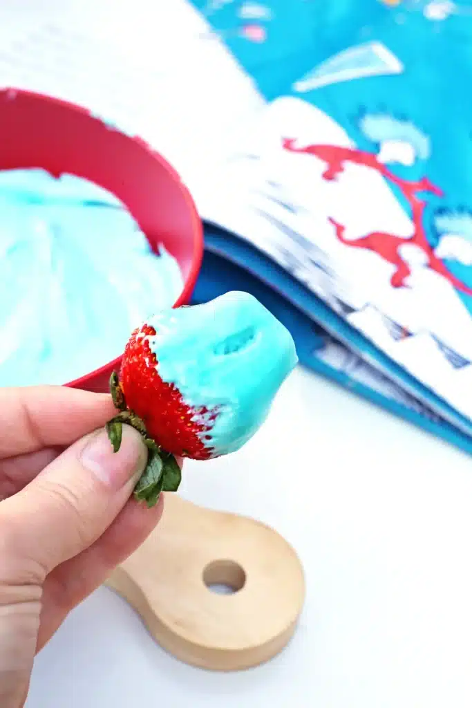 Thing 1 Thing 2 Fruit Dip - Cultivating Brilliant Minds a kid holding a strawberry with blue fruit dip on it