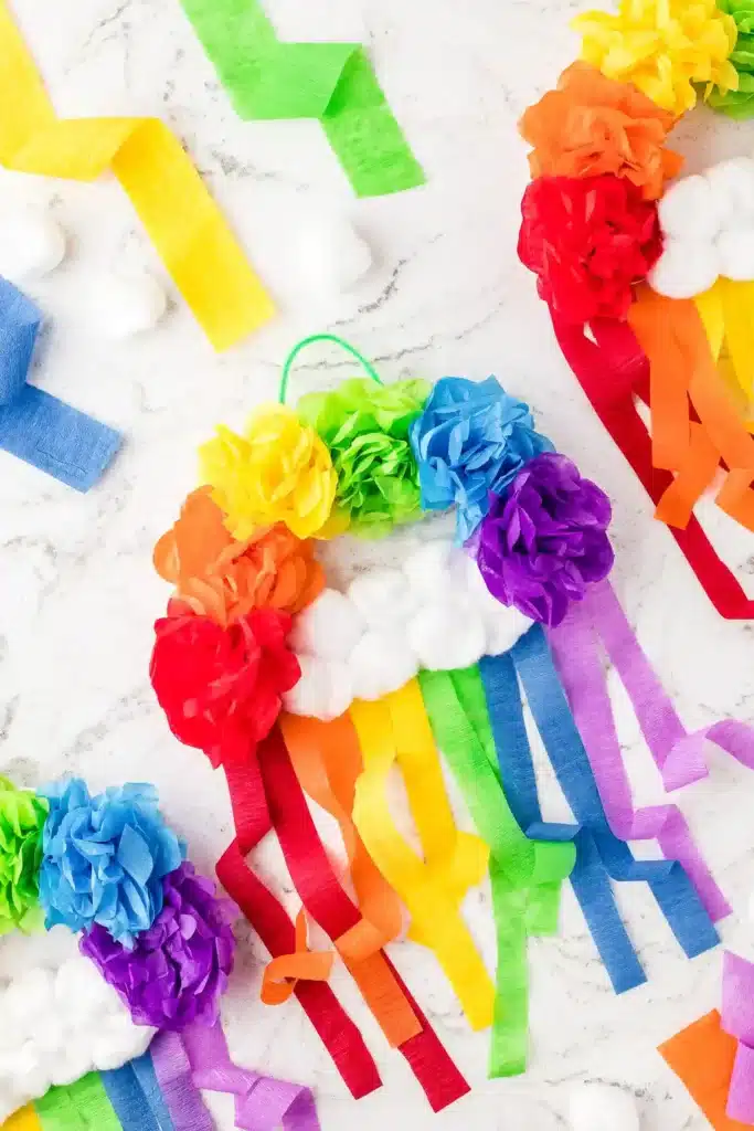 St. Patrick's Day Crafts For Kids - Cultivating Brilliant Minds flowers made out of tissue paper in rainbow order with cotton balls for clouds