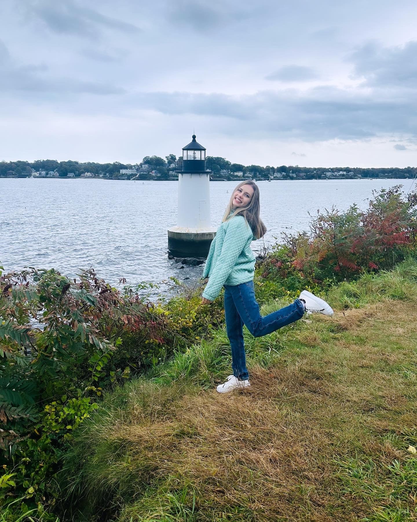 a photo of a girl in front of a light house