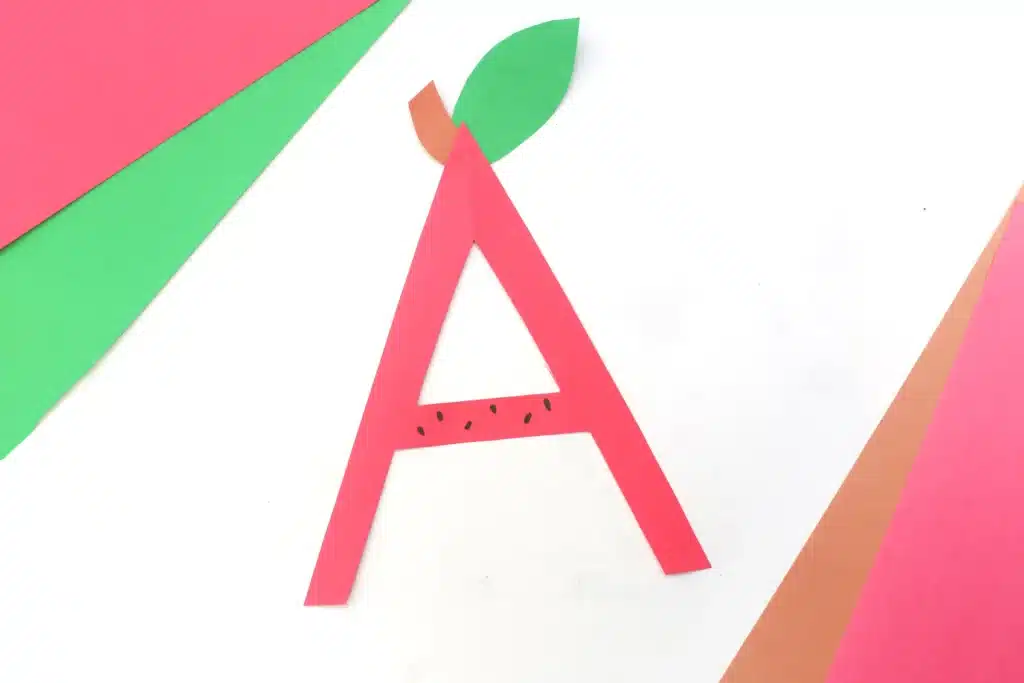 Letter A Apple Craft - Cultivating Brilliant Minds a letter a cut out of red construction paper with a leaf and stem glued on top