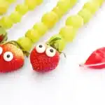 Caterpillar Grape Skewers - Cultivating Brilliant Minds skewers with grapes, a strawberry, and candy eyes on it to look like a caterpillar