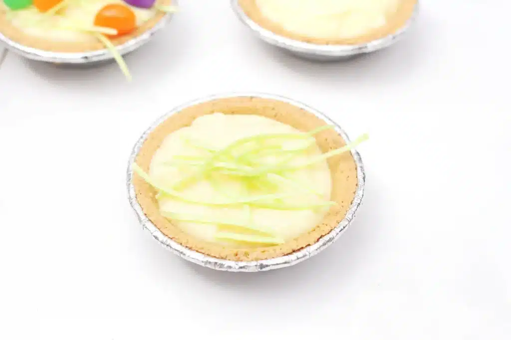 Peeps banana pudding mini pies - Cultivating Brilliant Minds a mini banana pudding pie with edible easter grass on top