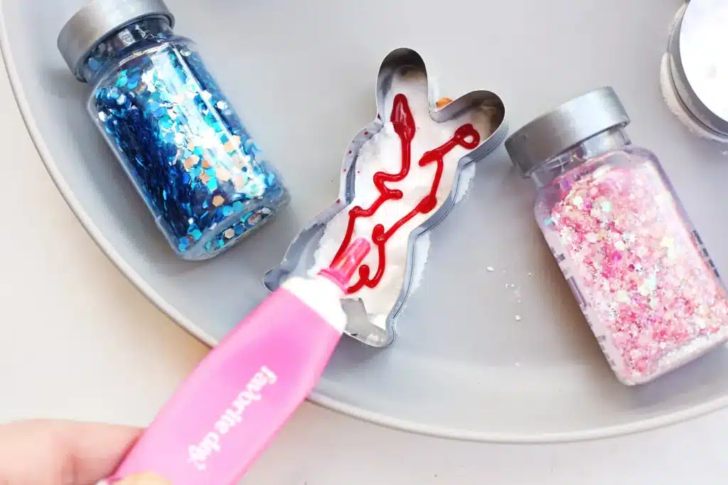 Fizzy Bunny Experiment - Cultivating Brilliant Minds a cookie cutter on a plate with baking soda in it and food coloring