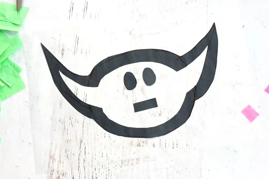 Baby Yoda Sun Catcher - Cultivating Brilliant Minds a baby yoda head cut out of construction paper with eyes and a mouth stuck on contact paper