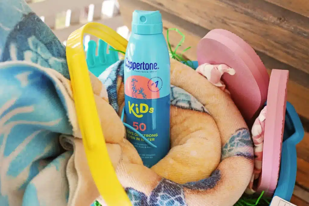 Beach Easter Basket Idea - Cultivating Brilliant Minds sunscreen and a towel in a beach bucket