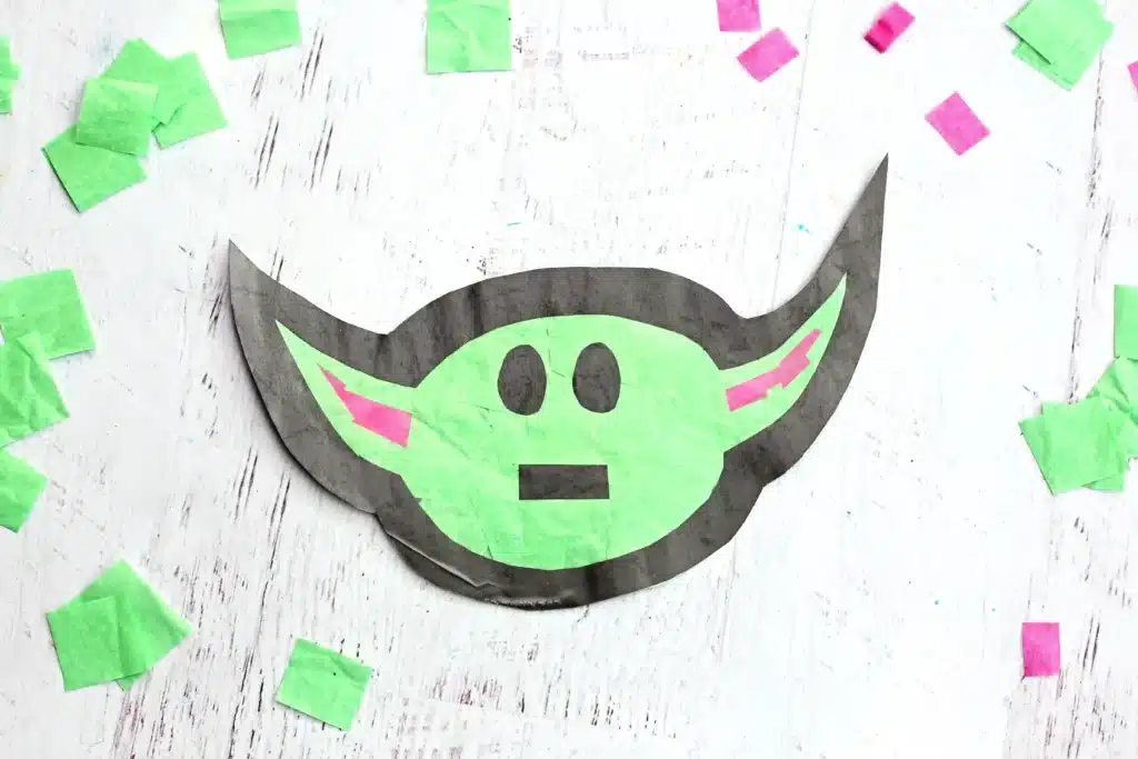Baby Yoda Sun Catcher - Cultivating Brilliant Minds a star wars craft of a baby yoda sun catcher made from construction paper, tissue paper, and contact paper