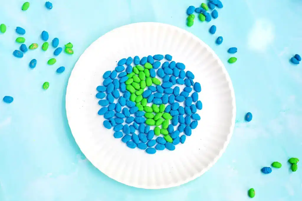 Bean Earth Day Mosaic - Cultivating Brilliant Minds an earth day art project that uses green and blue dyed pinto beans glued to a paper plate in the shape of the earth