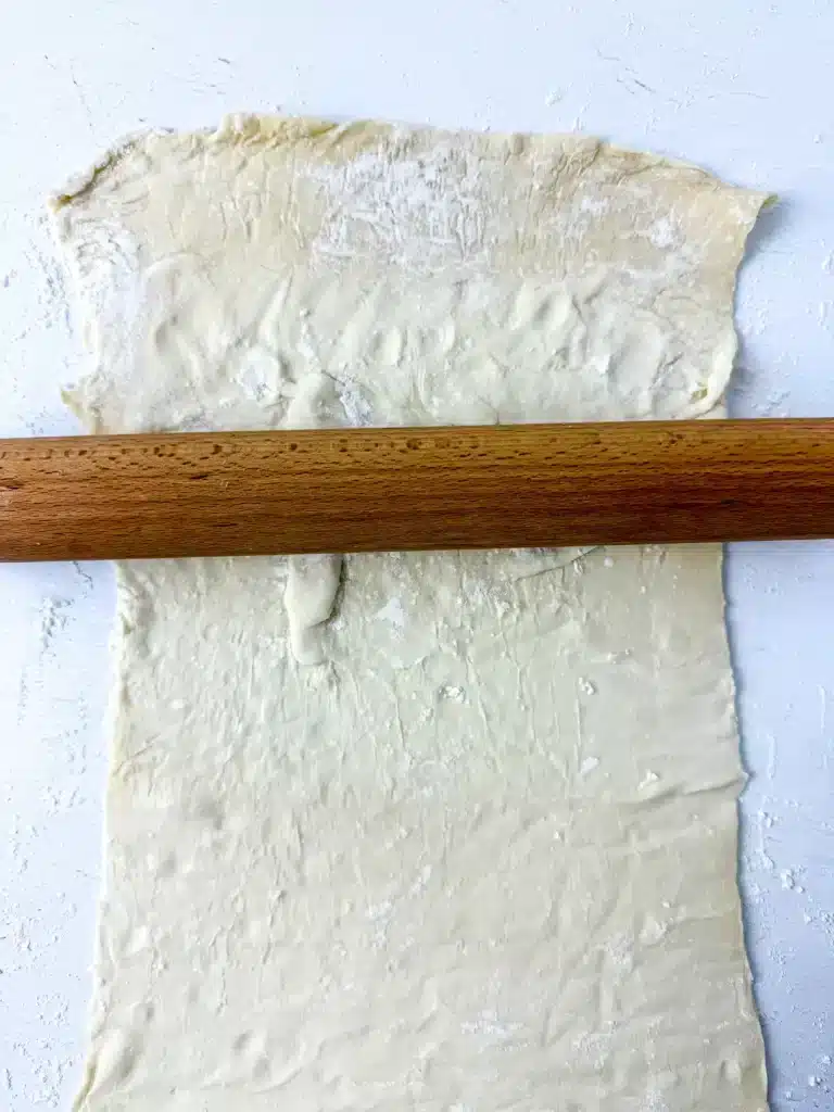 Blueberry Earth Day Hand Pies - Cultivating Brilliant Minds a rolling pin rolling out puff pastry